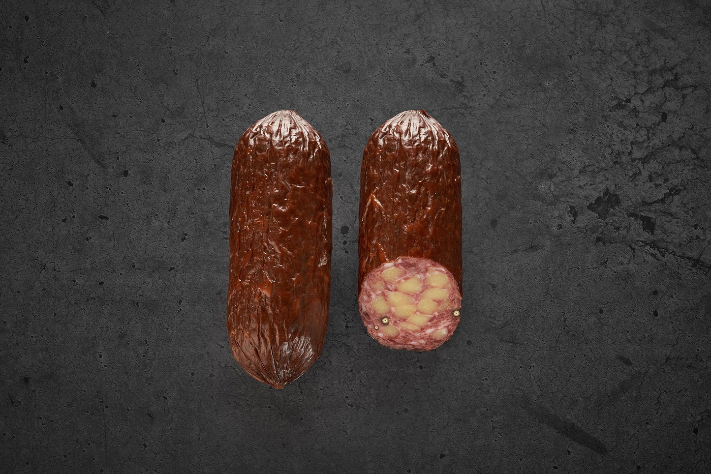 2 Stück Käsewurst aufgeschnitten. Große Käsestücke in der Wurst.