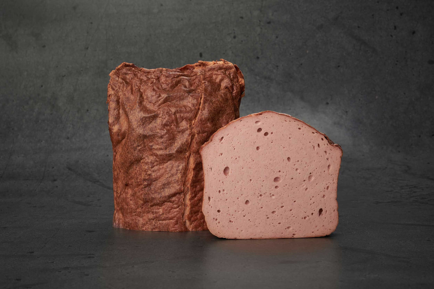 Leberkäse im Ganzen auf dunklem Hintergrund